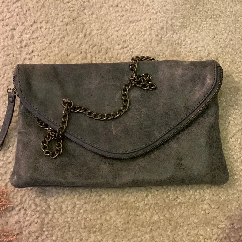 Grey leather envelope bag with zipper around flap.
